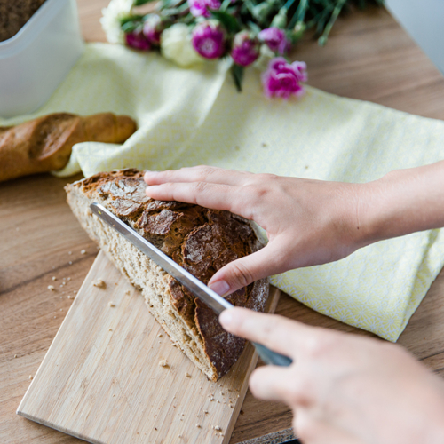 Jemand schneidet Bio-Brot.
