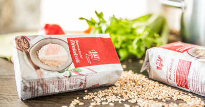 Zwei Packungen Ja! Natürlich Bio-Dinkelreis auf einem Tisch.