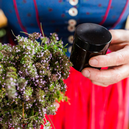 Eine Person hält Bio-Thymian und ein verschließbares Glas in der Hand.