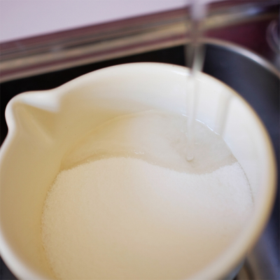 Jemand füllt Wasser in einen Topf.