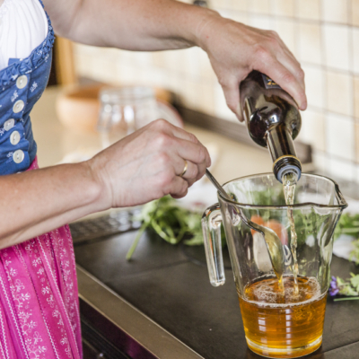 Jemand gießt Bio-Essig in eine Karaffe.