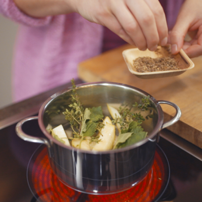 Jemand würzt etwas im Kochtopf.