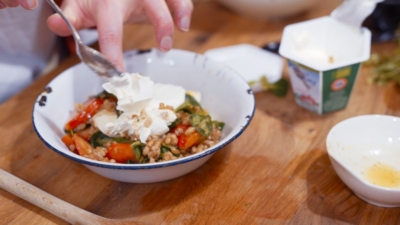 Jemand gibt Ja! Natürlich Bio-Ziegenfrischkäse über den Alles Salat.