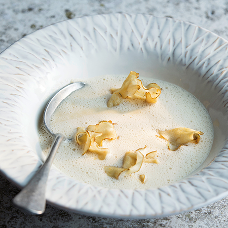 Ein Teller mit Topinamburschaumsuppe und Bio-Topinamburchips.