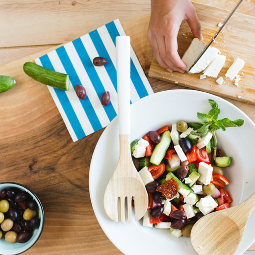 Ein griechischer Salat in einer Schüssel mit Holzlöffeln.