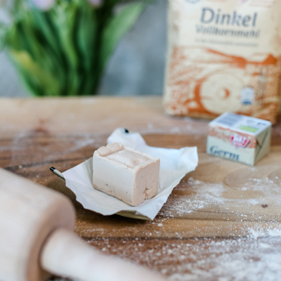 Offene Packung Ja! Natürlich Bio-Germ und Dinkelvollkornmehl im Hintergrund.