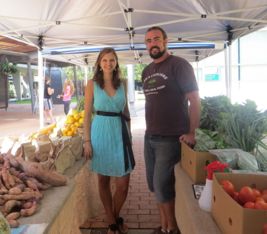 Elisabeth Berg mit einem Mann bei einem Gemüsestand.