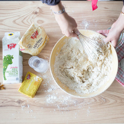 Jemand verrührt die Zutaten in einer Schüssel.