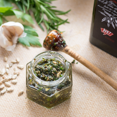 Ein Wildkräuter-Pesto im Glas, daneben eine Flasche Ja! Natürlich Bio-Olivenöl.