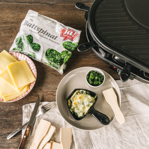 Raclette-Pfännchen mit Käse und Ja! Natürlich Bio-Blattspinat.