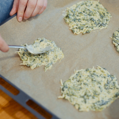 Jemand schmiert die Taco-Masse auf Backpapier.