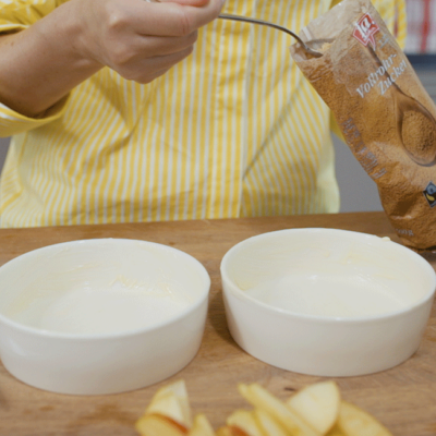 Jemand gibt Ja! Natürlich Bio-Vollrohrzucker in zwei Schalen.