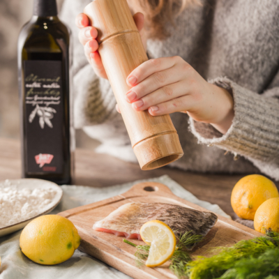 Jemand pfeffert ein Stück Bio-Fisch.