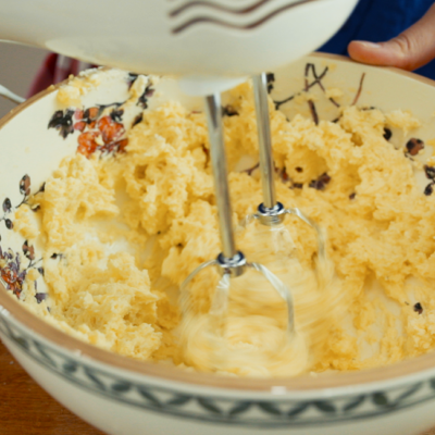 Jemand verarbeitet Erdäpfel mit Topfen, Mehl, Ei und Salz mit einem Handmixer.