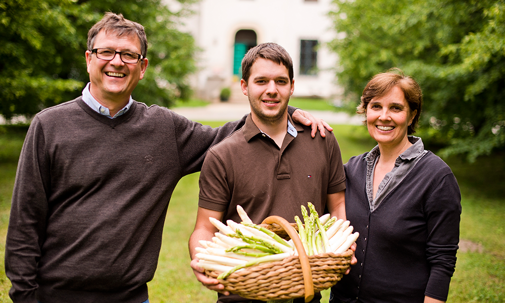 Familie Brandenstein steht vor dem Gut Markhof und hält einen Korb voll weißen Spargel in der Hand