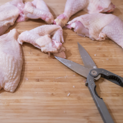 Jemand schneidet Bio-Hendl.