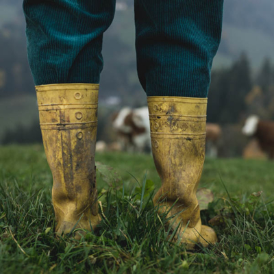 Jemand in gatschigen Gummistiefeln.