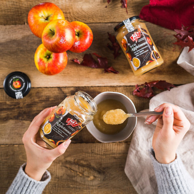 Jemand löffelt aus einem Glas Ja! Natürlich Bio-Apfelmus.