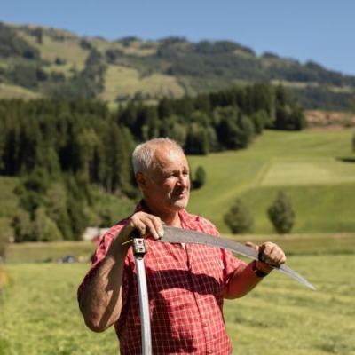 Bio-Bauer Martin Rieder mit Sense auf der Weide - Ja! Natürlich