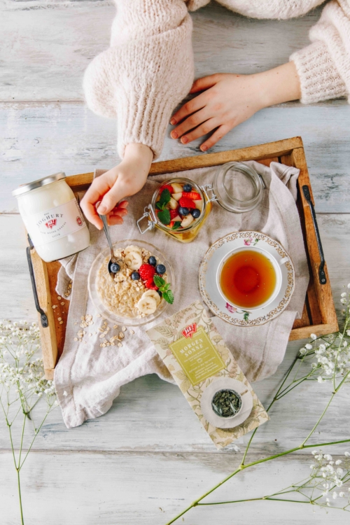 Ein Frühstückstablett mit Ja! Natürlich Bio-Morgentau Tee, Joghurt, Porridge und Früchten.