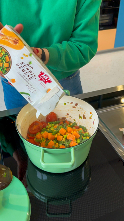 Bio-Kürbisgemüse Mischung wird in den Topf geleert