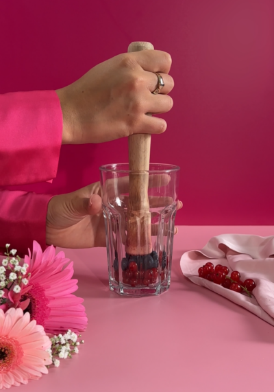 Jemand stampft Bio-Beeren in einem Glas.