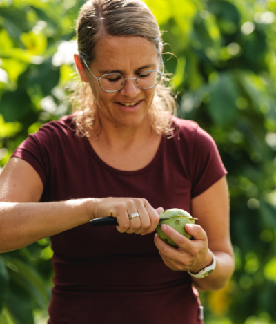Angelika Köck schneidet Bio-Papau von Ja! Natürlich auf