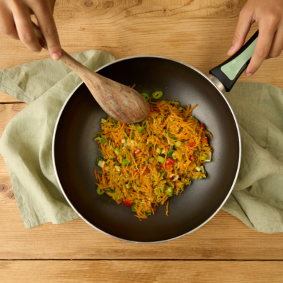 Jemand dünstet Bio-Gemüse in einer Pfanne an.