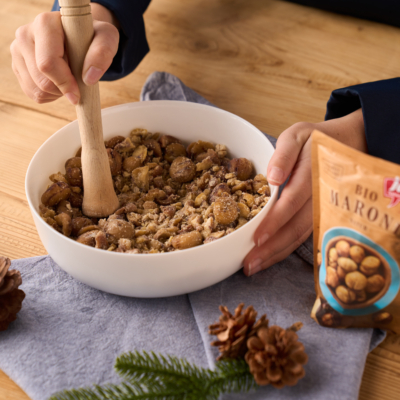 Jemand zerstampft in einer Schüssel Ja! Natürlich Bio-Maroni.