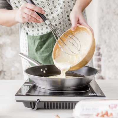 Jemand leert Bio-Protein-Pancaketeig in eine Pfanne.