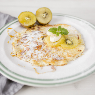 Ein Teller mit Bio-Protein-Pancakes und Kiwis.