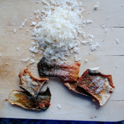 Bio-Seesaibling-Tatar mit knusprigen Fisch-Chips auf einem Schneidebrett.