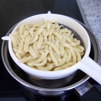 Bio-Spätzle werden in einem Sieb abgeseiht.