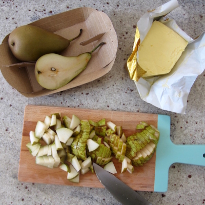 Geschnittene Bio-Birnen mit einer Packung Butter daneben.