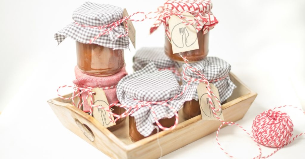 Bio-Marmeladengläser auf einem Holztablett.