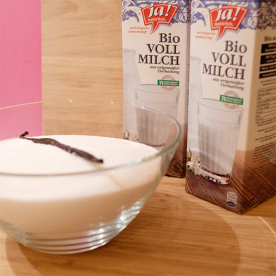 Eine Schale Vollmilch, daneben zwei Kartons Ja! Natürlich Bio-Vollmilch.