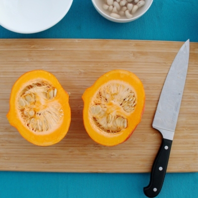 Geschnittener Bio-Kürbis auf einem Holzbrett.