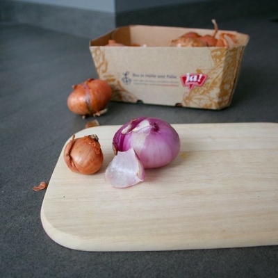 Ja! Natürlich Bio-Zwiebeln auf einem Schneidebrett.
