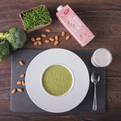 Mandeldrink-Brokkolisuppe in einer Schale, daneben der Bio-Mandeldrink von Ja! Natürlich.