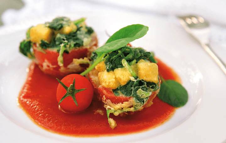 Paradeiser mit Spinat-Mehrkorntoastfülle auf pikantem Paradeiserragout
