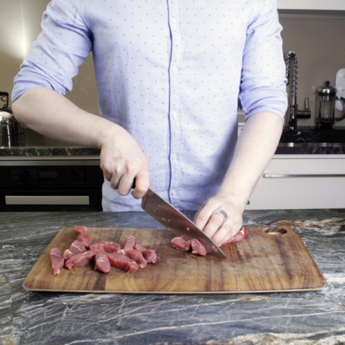 Jemand schneidet Bio-Rindfleisch.