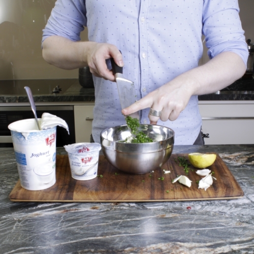 Ja! Natürlich Bio-Joghurt, Crème fraîche, Kräuter und Zitronen werden in einer Schüssel zusammengerührt.