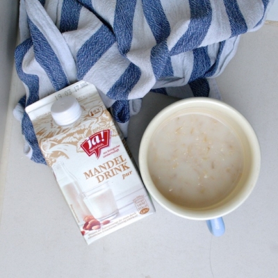 Eine Packung und eine Tasse Ja! Natürlich Bio-Mandeldrink.