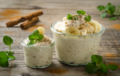Zwei Gläser mit Bio-Porridge und Bananen.