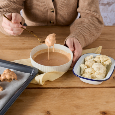 Jemand mariniert einen Bio-Karfiol.