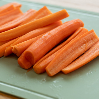 Geschnittene Bio-Karotten auf einem Schneidebrett.