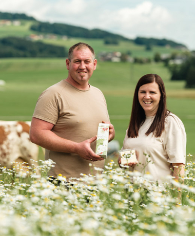 Bio-Bauer und -Bäuerin mit Heumilchprodukten auf der Weide - Ja! Natürlich
