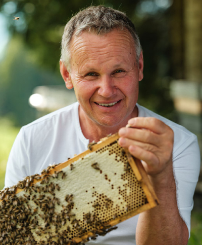 Bio-Bauer Johann Irreger mit einer Zarge aus einem Bienenstock.