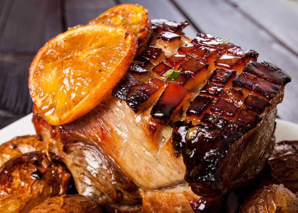 Orangen-Whiskey-Bio-Schweinsbraten auf einem Teller.