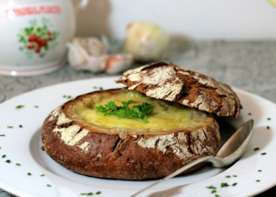 Französische Bio-Zwiebelsuppe im Brot auf einem Teller.